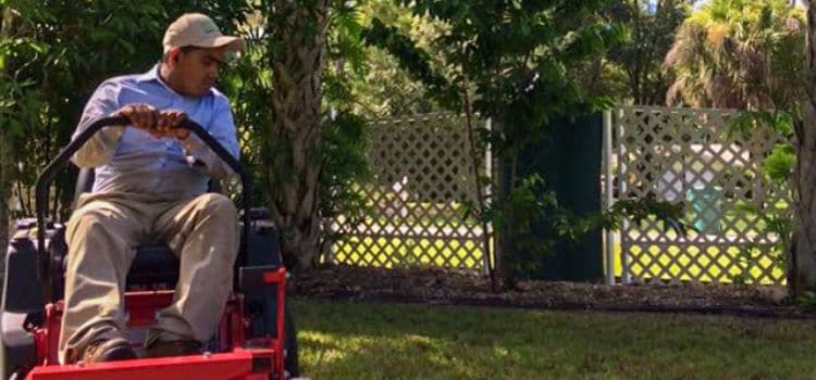 A Leo Garden Care employee mowing a lawn.