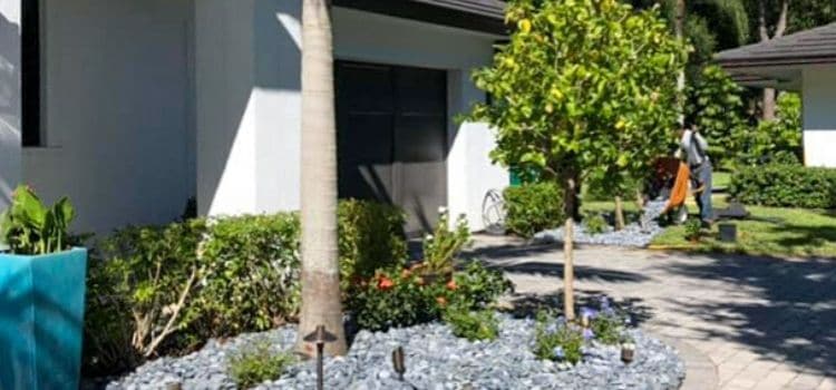 A Leo Garden Care employee in the process of installing decorative rock beds.