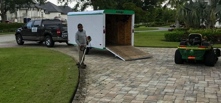 A Leo's Garden Care employee neatly edging a driveway.